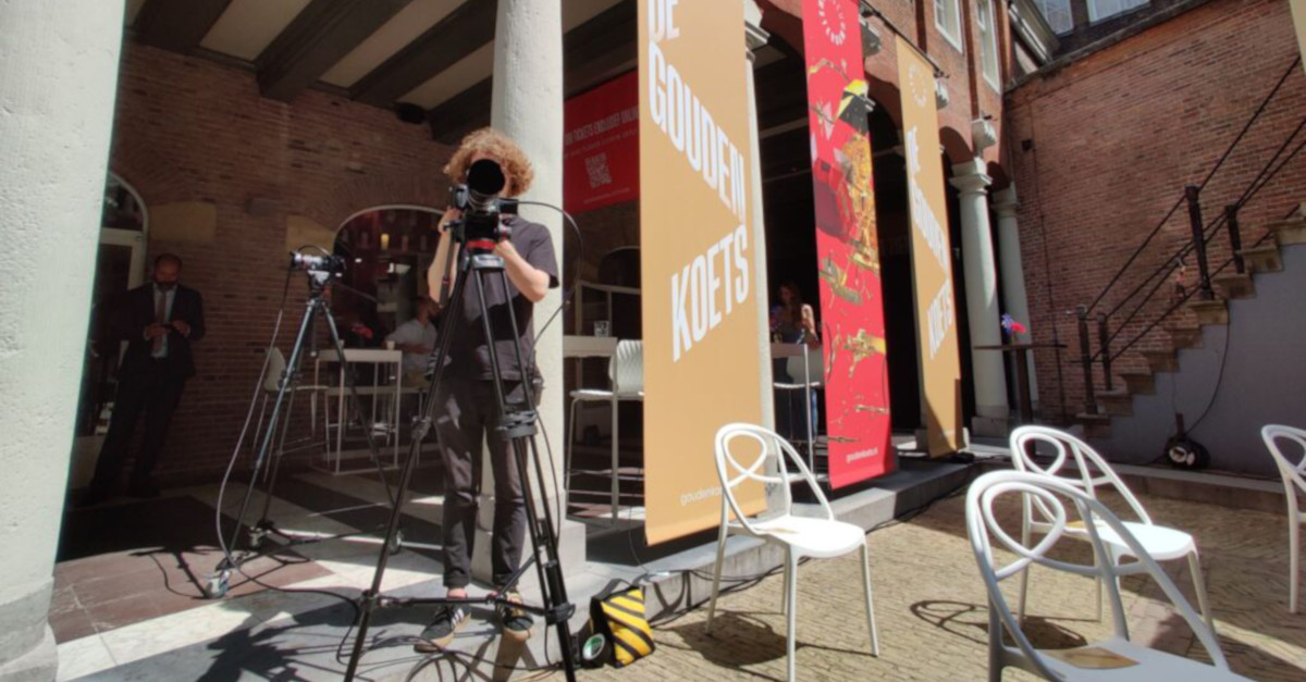 Een camera man van Objektiv staat op een binnenplaats te filmen